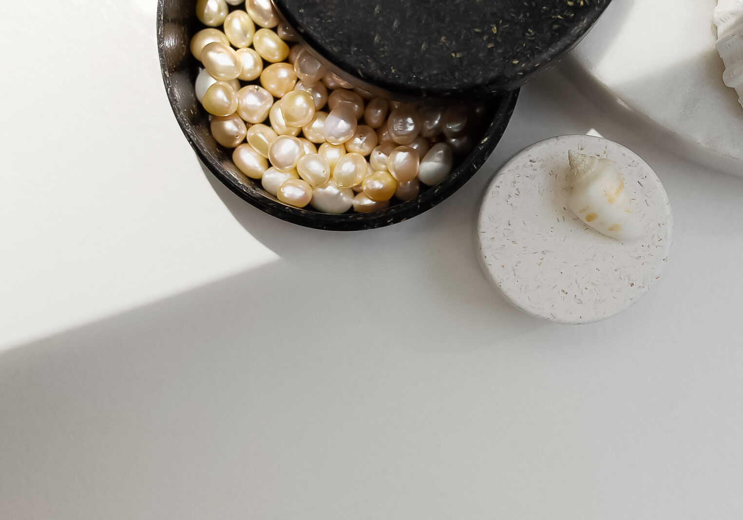 Premium product photo of a biodegradable jewellery box full of real ocean pearls in different colors.
